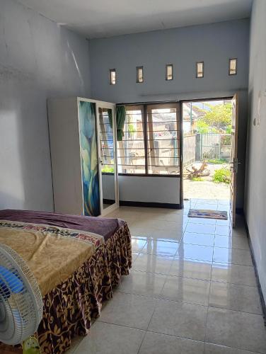a bedroom with a bed and a large glass door at Bale Sasak guest house in Selaparang