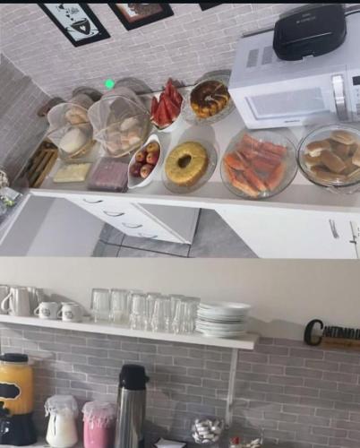 two shelves with different types of donuts on them at Belo Hotel in Ribas do Rio Pardo