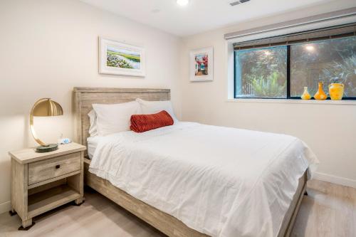 a bedroom with a white bed and a window at Seasons at Leschi Hillsides in Seattle