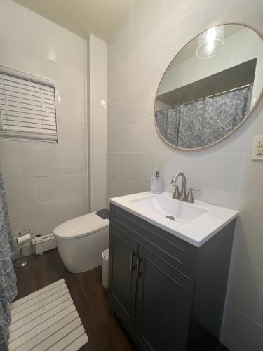a bathroom with a sink and a mirror and a toilet at Cerca de Nueva York, Confortable in West New York