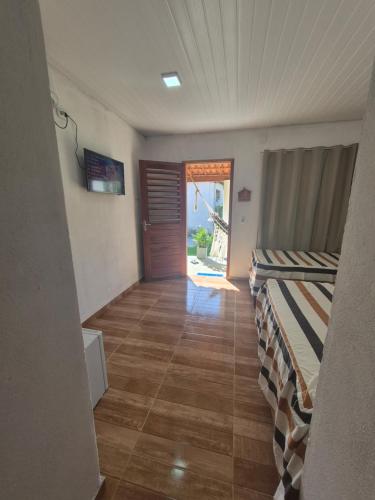 an empty room with a hallway with a door and a floor at Chalés Brisa do Mar in Amontada