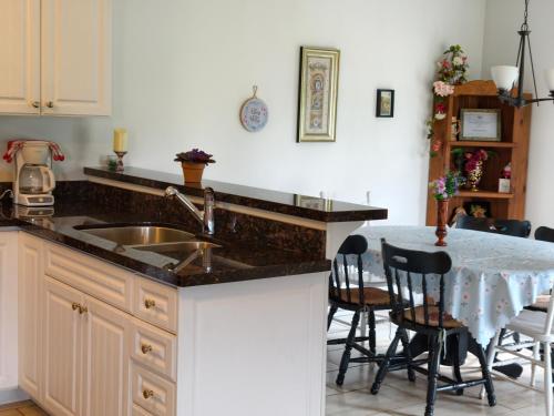 a kitchen with a sink and a table with chairs at Near Cavendish Beach-2 in Stanley Bridge