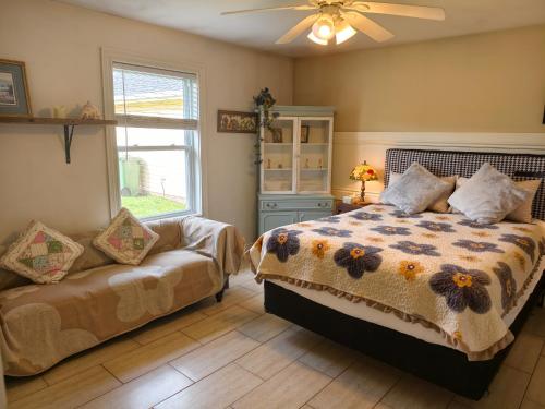 a bedroom with a bed and a couch and a window at Near Cavendish Beach-2 in Stanley Bridge