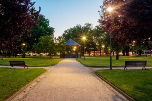 a park with two benches and a gazebo at night at Summer East Apartments in Orange