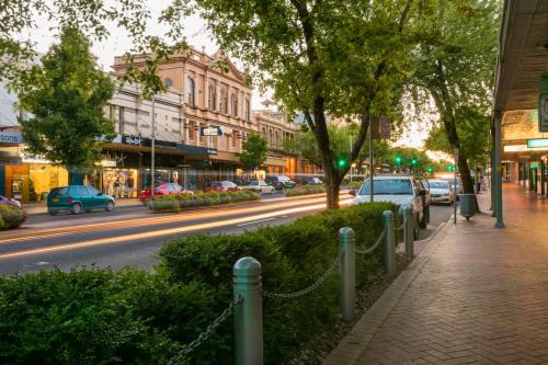 a city street with cars parked on the road at Summer East Apartments in Orange