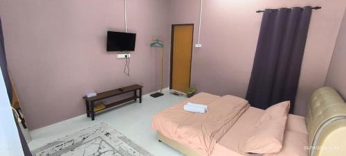 a small room with a bed and a television at IA Tiny House 2 in Dungun