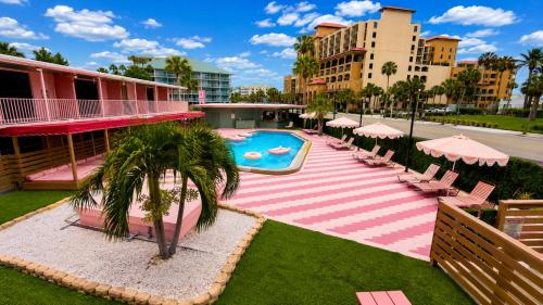 a pool with chairs and umbrellas next to a building at Abode Beach House in Clearwater Beach