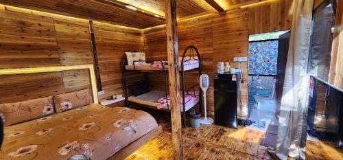 a bedroom of a log cabin with a bunk bed at Sameer Mountain View Retreat in Tanah Rata