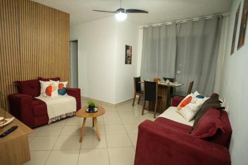 a living room with a couch and a bed and a table at Apartamento Morada dos Sonhos in Lauro de Freitas