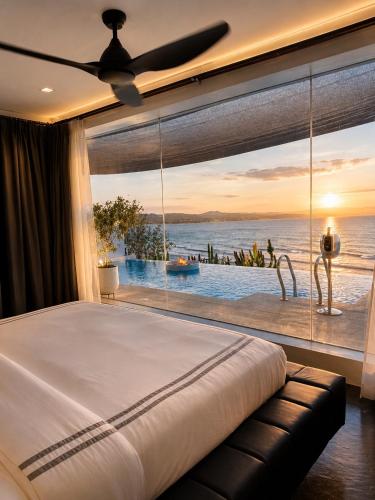 a bedroom with a large window with a view of the ocean at Epic Suites Bohol ADULTS ONLY in Dauis