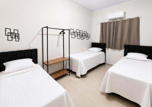a bedroom with two beds and a mirror in it at Casa Harmonia - Ar Condicionado in Bom Jesus da Lapa