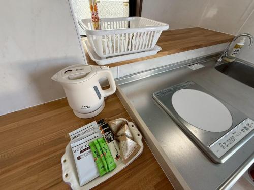 a kitchen counter with a sink and a toilet at Villa resort -悠- in Miyakojima