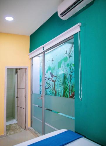 a room with a green wall with a sliding glass door at Muramar 43 Hotel Cartagena in Cartagena de Indias