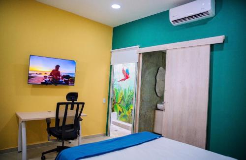 a bedroom with a bed and a desk and a tv at Muramar 43 Hotel Cartagena in Cartagena de Indias
