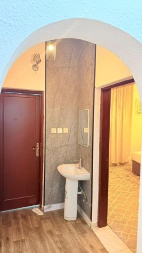 a bathroom with a sink next to a door at استراحة الرايس in Rayyis