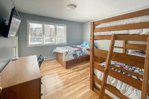 a bedroom with two bunk beds and a desk at Waterville Vacation Condo in Waterville Valley