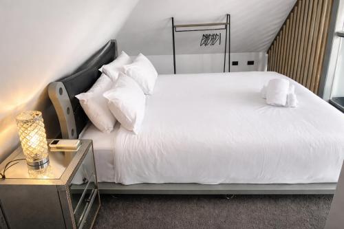 a bedroom with a large white bed and a table at Hobart Retreats - Sanctuary and Haven in Hobart