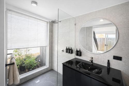 a bathroom with a sink and a mirror at Hobart Retreats - Sanctuary and Haven in Hobart