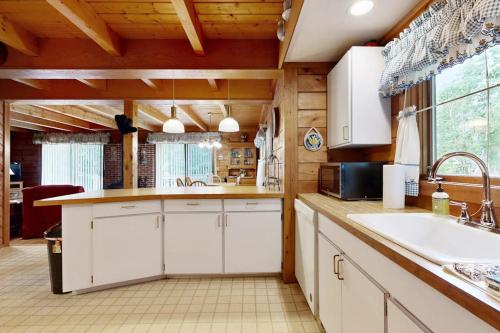 a kitchen with white cabinets and a sink at Saco River Hideaway in Bartlett
