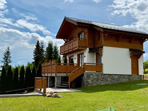 a house with a large deck and a lawn at Villa Bergbliss in Bukovel