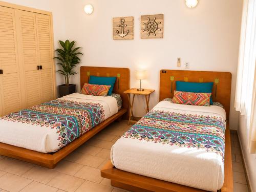 a bedroom with two beds and a table at Hermoso apartamento en Manzanillo con alberca y cancha de tenis, Ideal para relajarse y disfrutar de una escapada tranquila en el paraíso tropical in Manzanillo