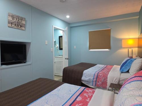 a hotel room with two beds and a flat screen tv at Lakeview Motel & Cottage in Kincardine
