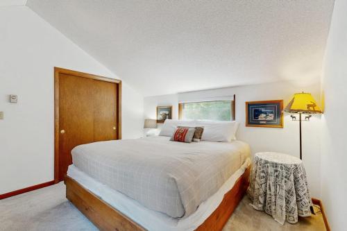 a bedroom with a large white bed and a lamp at Sleepless in Snowood in Thornton