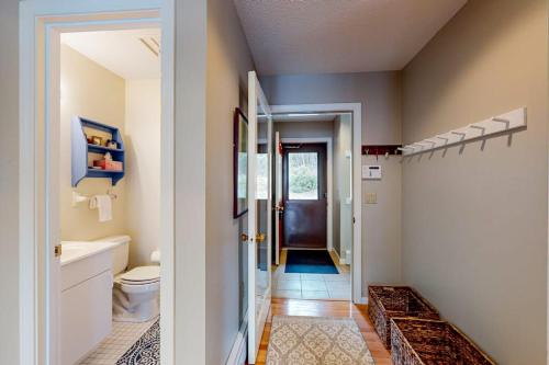 a bathroom with a toilet and a sink and a door at Lake View by the Mountain in Bridgton