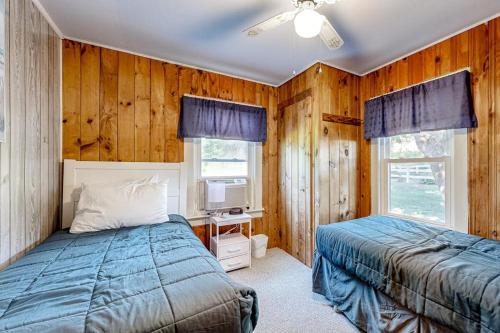 a bedroom with wooden walls and a bed and a tv at Seaside Cottage in Wells