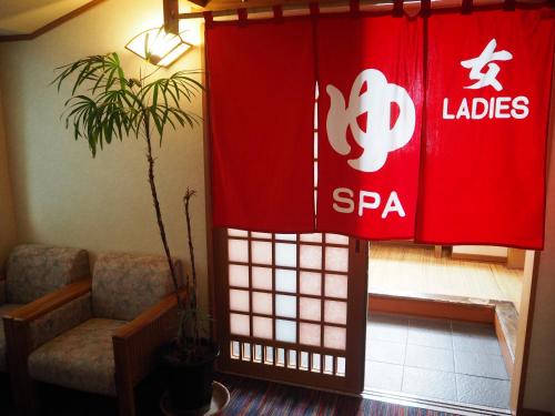 a living room with a red curtain and a plant at Hotel Asafuji in Fujikawaguchiko