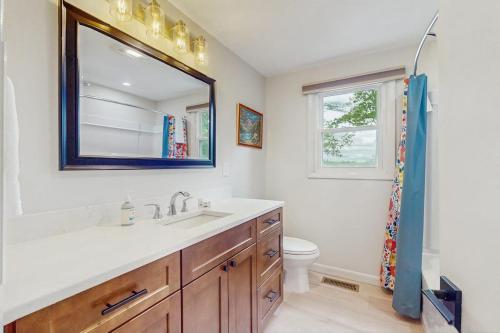 a bathroom with a sink and a toilet and a mirror at Duncan Cottage in Ossipee