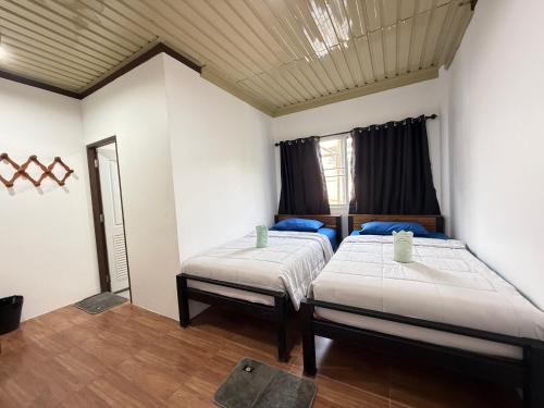 a bedroom with two beds and a mirror at ปิล๊อกพอเพลิน-pilokporploen in Ban Pilok Khi