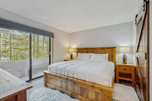 a bedroom with a bed and a large window at Loon Mountain Nest in Lincoln