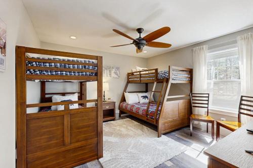 a room with three bunk beds and a ceiling fan at Cranmore Road 7 in North Conway
