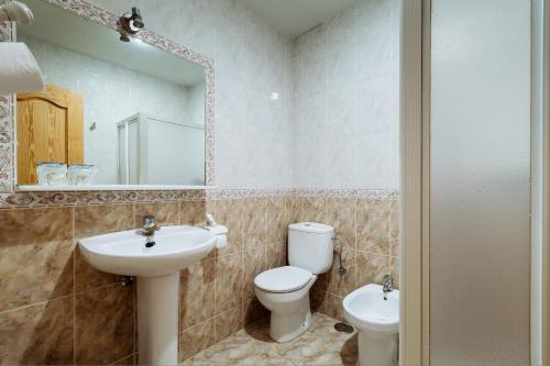 ein Badezimmer mit einem Waschbecken, einem WC und einem Spiegel in der Unterkunft Hotel Philadelfia in Peligros