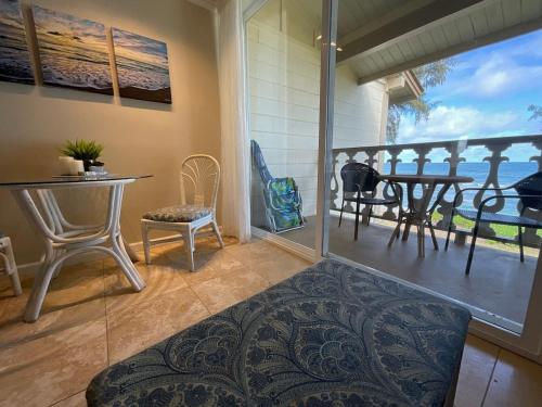 a room with a balcony with a table and chairs at Oceanfront Studio at Islander on the Beach #325 in Kapaa