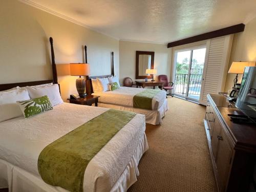 a hotel room with two beds and a television at Oceanview Studio at Kauai Beach Resort #2444 in Lihue