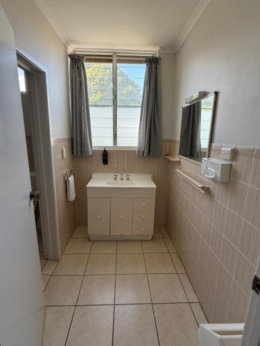 a bathroom with a sink and a window at Tower Court Motel in Hervey Bay
