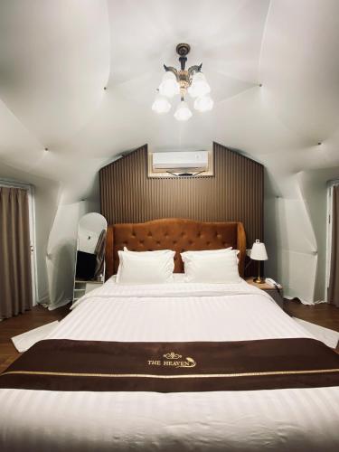 a bedroom with a large white bed with a ceiling at The Heaven Royal Glamp in Bedakah
