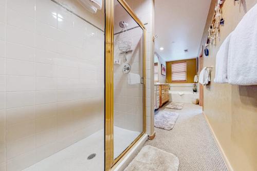 a bathroom with a shower with a glass door at Evergreen Retreat, Unit 101 in Avon