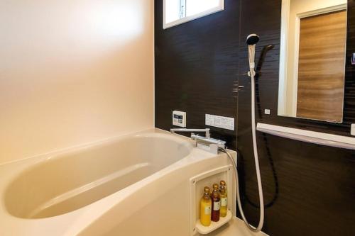 a bath tub in a bathroom with a shower at 萩別邸 シーサイド1 HAGI Bettei SEASIDE1 in Hagi