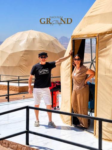 a man and a woman standing outside of a tent at WADI RuM GRAND in Wadi Rum