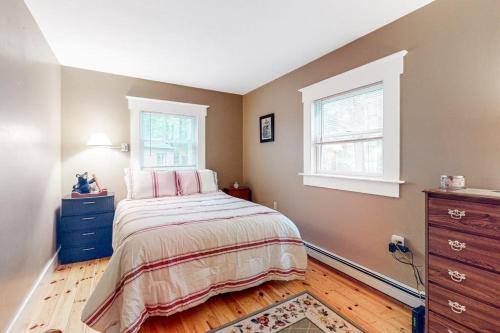 a bedroom with a bed and a dresser and two windows at Sheridans Getaway in Newry