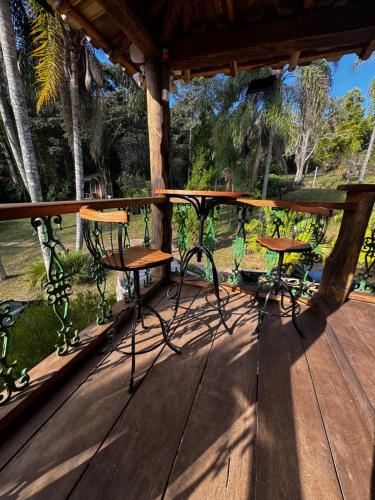 a wooden deck with a table and chairs on it at Retiro Real in Santo Antônio do Leite
