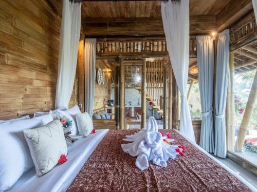 a bedroom with a large bed in a house at Uma Bali-Bamboo House in Selat