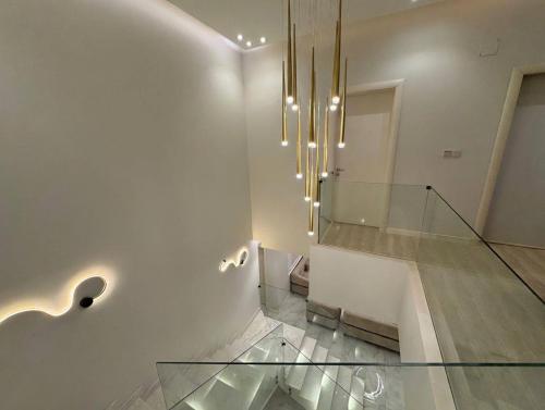 a room with a glass staircase and a chandelier at Over lock in Buraydah