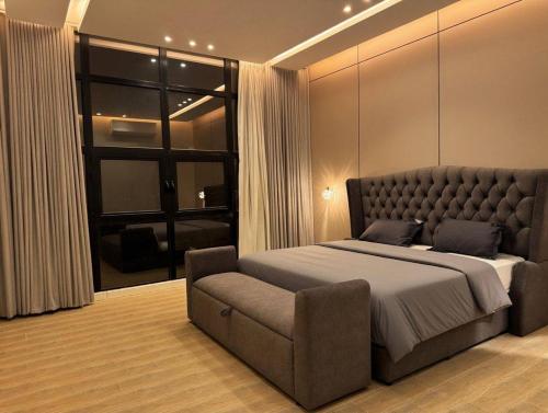 a bedroom with a large bed and a couch at Over lock in Buraydah