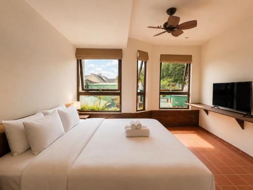 a bedroom with a large white bed with a ceiling fan at Camly the Boutique in Da Lat