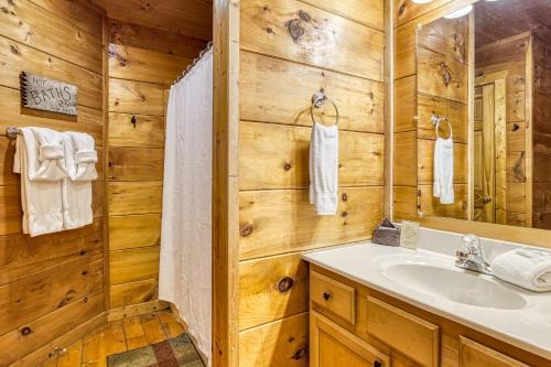a bathroom with a sink and a mirror at Naughty Pines in Pigeon Forge