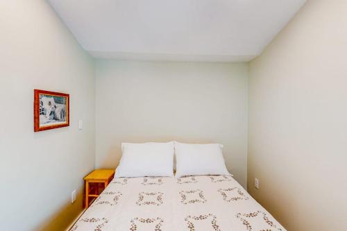 a small bedroom with a bed with white walls at Shorelands, Unit 44-3 in Kennebunk